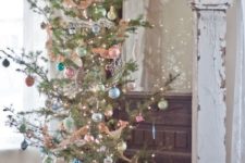 a Christmas tree with lights and pastel ornaments of various colors for a chic vintage feel