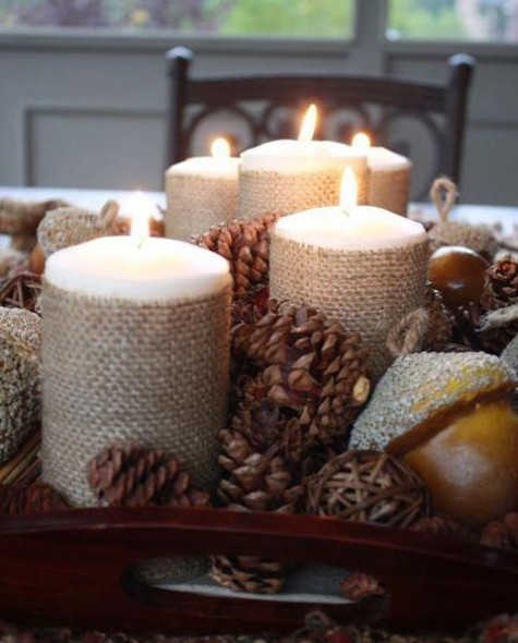 a rustic Christmas centerpiece of a tray, pinecones, vine balls, nuts, candles covered with burlap is a creative idea