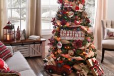a rustic vintage Christmas tree withburlap ribbons, colorful lights, a hat on top, a toytruck and gift boxes