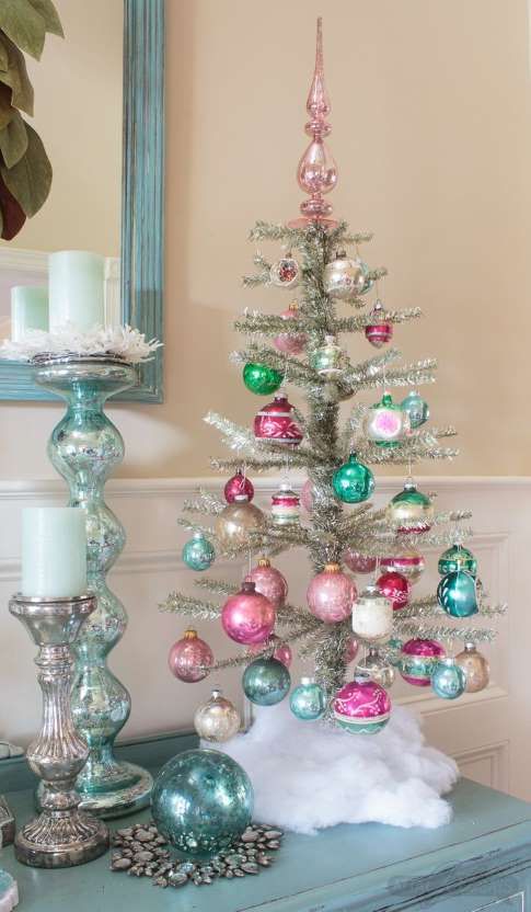 a silver tabletop Christmas tree with bright pink and turquoise ornaments looks cute and very chic