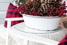 a white bathtub with oversized pinecones, berries is a bold outdoor Christmas decoration to go for