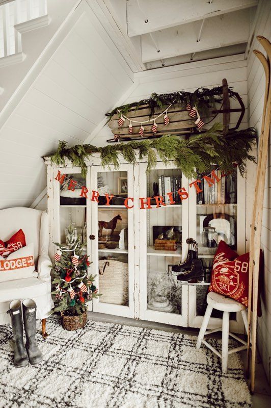 evergreens, a sleigh with mitten garlands, red letter garlands, a mini tree in a basket and red pillows