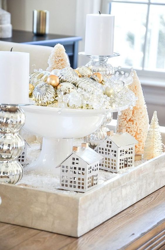 refined vintage Christmas decor with a tray, little houses, bottle brush trees, pillar candles and a bow with mercury glass ornaments
