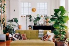 a boho meets mid-century modern living room with prints, a mustard sofa, potted plants and rattan and wicker touches