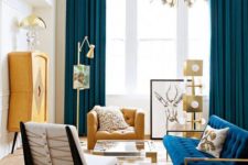 a colorful mid-century modern space with a sunburst chandelier, navy and yeloow items, metallic touches and prints