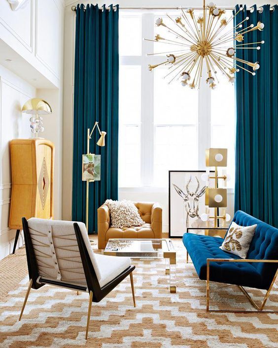 A colorful mid century modern space with a sunburst chandelier, navy and yeloow items, metallic touches and prints