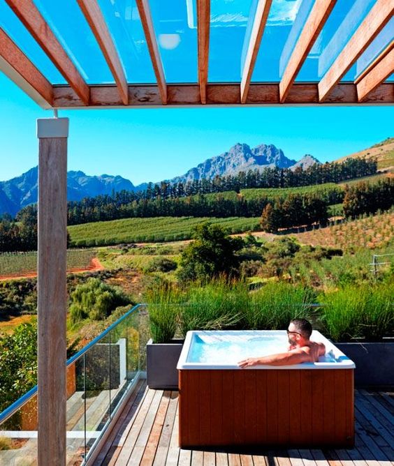 a deck with jacuzzi and a fantastic mountain and hill view is an amazing idea to have a rest
