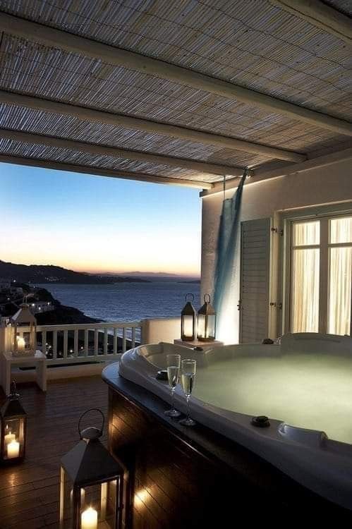 a dreamy space with a lit up jacuzzi, candle lanterns around and a sea view is a gorgeous place to spend some time
