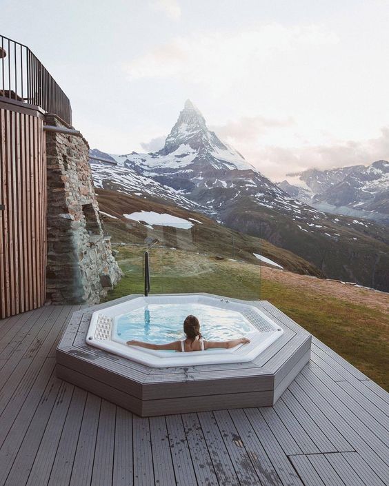 A hexagon shaped built in jacuzzi with a fantastic view of the snowy mountains is an amazing space to enjoy the views and relax