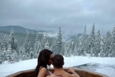 a jacuzzi built into a deck, with snow around and a fab view of the snowy forest is a lovely and cool idea