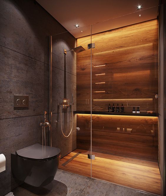 A minimalist moody bathroom with a shower space clad with wood, with built in lights, with grey stone tiles