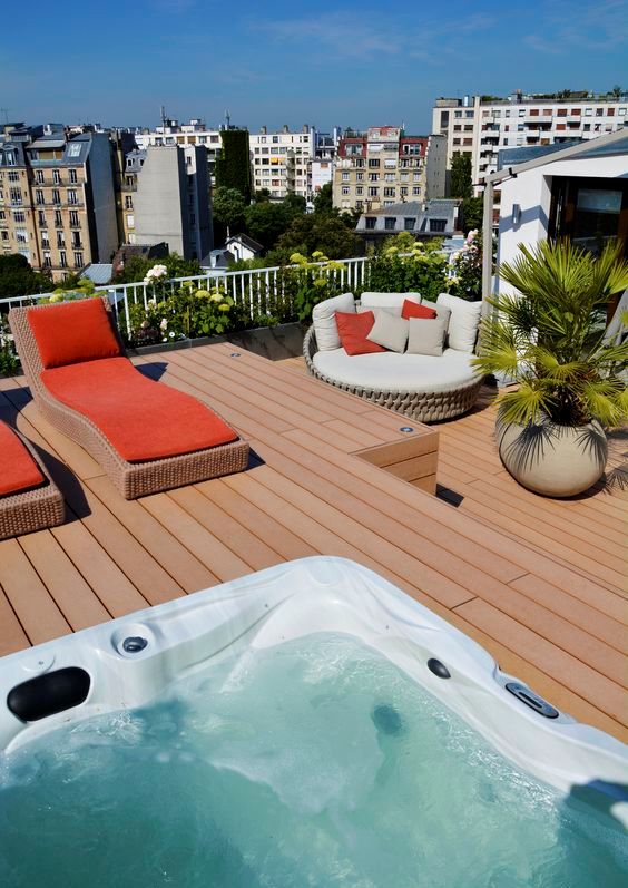 a rooftop deck with loungers, a daybed with pillows, potted plants and a jacuzzi plus a lovely sea view is amazing