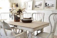 a shabby chic dining room with white shiplap walls, mismatched furniture, a large gallery wall and a vintage chandelier