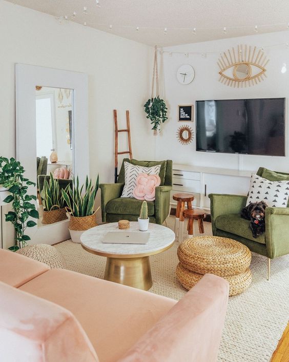 a sweet green and pink living room with potted greenery, jute ottomans, touches of gold and artworks