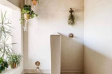 a Moroccan-inspired bathroom with greenery in planters suspended over the tub and on the windowsill