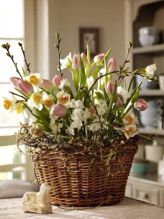 a basket with vines, pink tulips and daffodils, pussy willow is a cool Easter-inspired arrangement