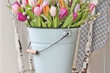 a blue bucket with colorful tulips and pussy willow is ideal for rustic Easter decor