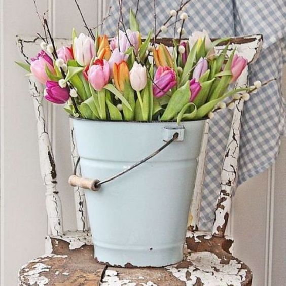 a blue bucket with colorful tulips and pussy willow is ideal for rustic Easter decor