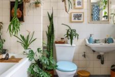 a bright blue and white bathroom with lots of greenery in various pots here and there feels alive