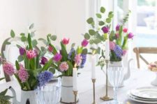 a bright spring table setting with colorful floral centerpieces, gilded touches and an uncovered table