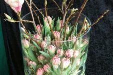 a chic flower arrangement of pink tulips and pink cherry blossom in a large jar