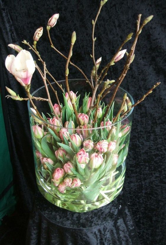 a chic flower arrangement of pink tulips and pink cherry blossom in a large jar