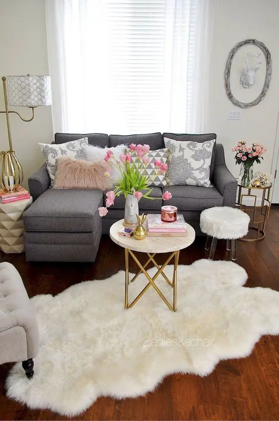 a chic spring living room with gold touches, neutral textiles, pink blooms and accents is a romantic and chic space