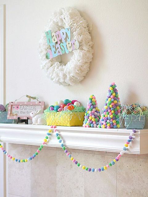 a colorful and fun Easter mantel with a coffee filter wreath and colorful letters, colorful pompom cones, colorful eggs and a garland