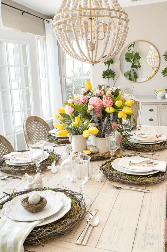 a colorful rustic Easter tablescape with vine wreaths and moss, nests with eggs, bunnies, bold blooms and greenery