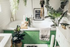 a contemporary bathroom with small tiles, lots of suspended planters with greenery and plants here and there