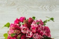 a cool Easter flower arrangement in bright pink, with foliage placed into a large cabbage
