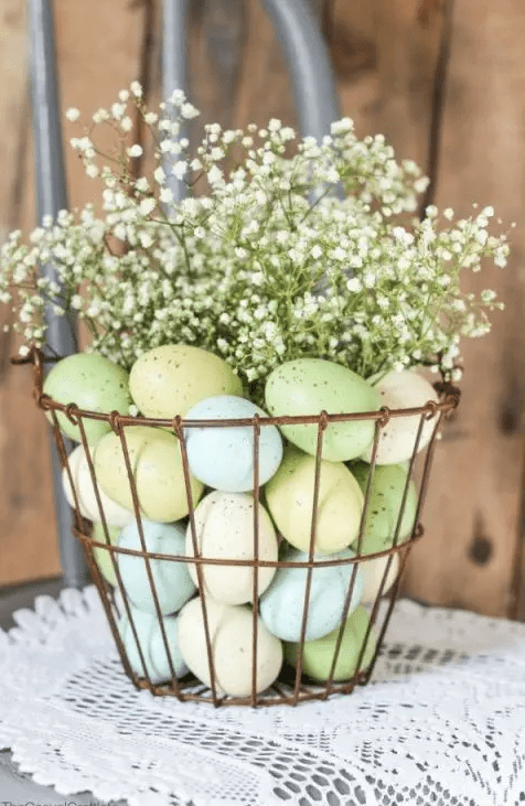 a copper wire basket with pastel eggs and baby's breath is a cool arrangement or centerpiece for Easter