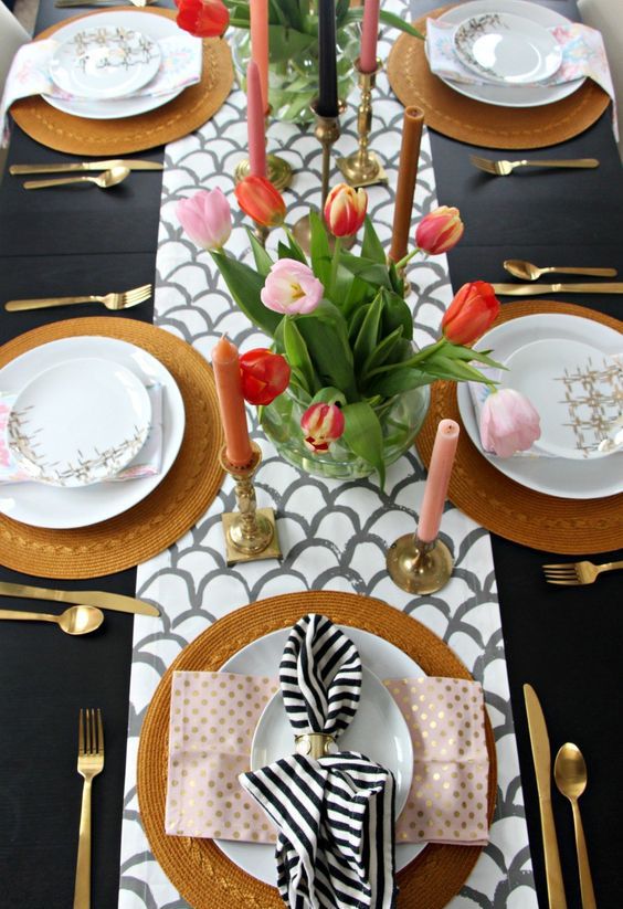 a fish scale runner, pink candles, a bright tulips centerpiece, wicker chargers and printed napkins