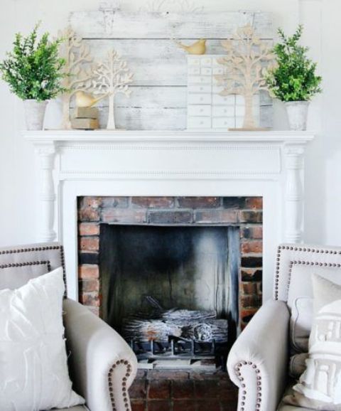 a fresh and inspiring mantel with potted greenery and cardboard trees plus some birdies