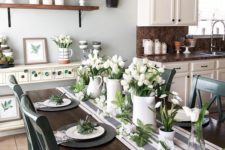 a fresh spring tablescape with a striped table runner, black matte chargers, white porcelain and white tulips centerpieces