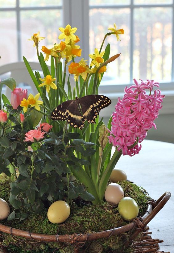 a garden-inspired flower arrangement with colorful spring bulbs in a basket with moss and pastel eggs