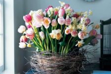 a lush flower arrangement of pink tulips and white daffodils placed in a nest screams Easter
