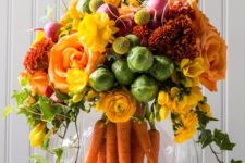 a lush spring or Easter flower arrangement of yellow, red and orange blooms, cabbage and carrots in the aquarium