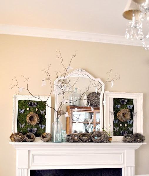 a mantel done with lots of nests with eggs, branches with paper birds and chalkboards with butterflies