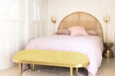 a marigold upholstered bench and pink bedding make this neutral space feel very spring-like