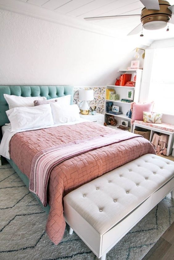 a mint grene upholstered bed, peahcy pink bedding and a floral half wall for a spring feel in the room