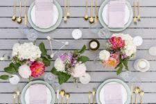 a modenr spring tablescape with bright floral centerpieces, blush napkins and geometric touches