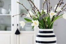a modern Easter flower arrangement with a black and white striped vase, pussy willow, white blooms and feathers