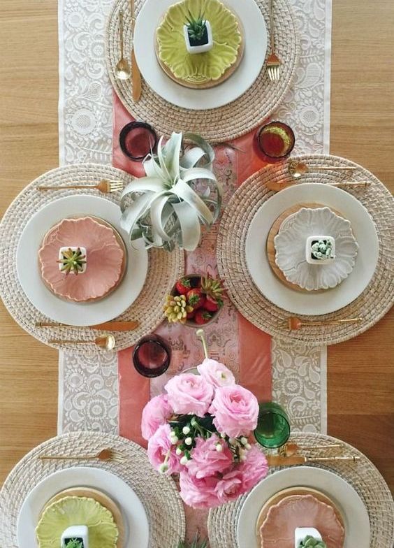 a modern colorful spring tablescape with succulents, pink roses, colorful plates and wicker chargers