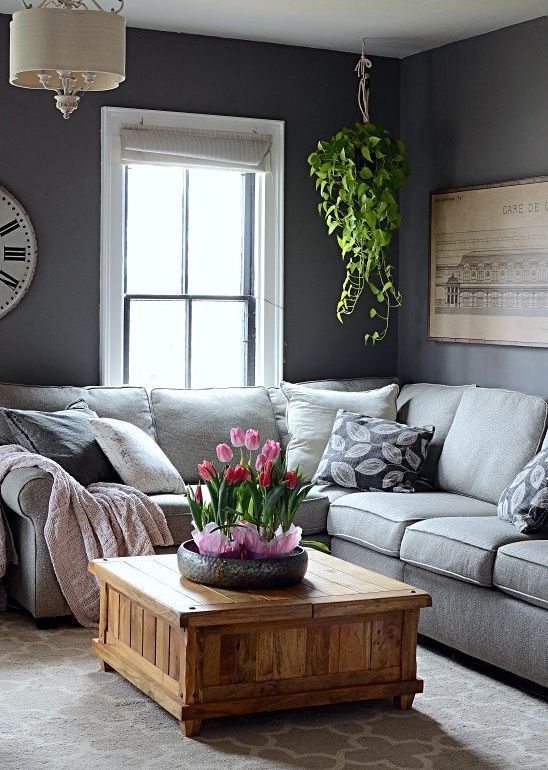 A monochromatic living room with potted plant and some tulips that refresh the space and make it spring like