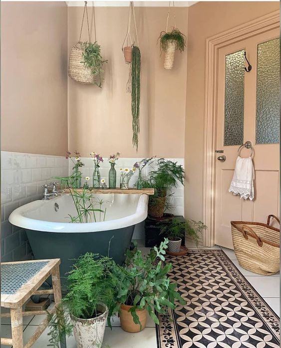 a neutral bathroom with greenery on the floor and hanging from the ceiling is a warm and cool space