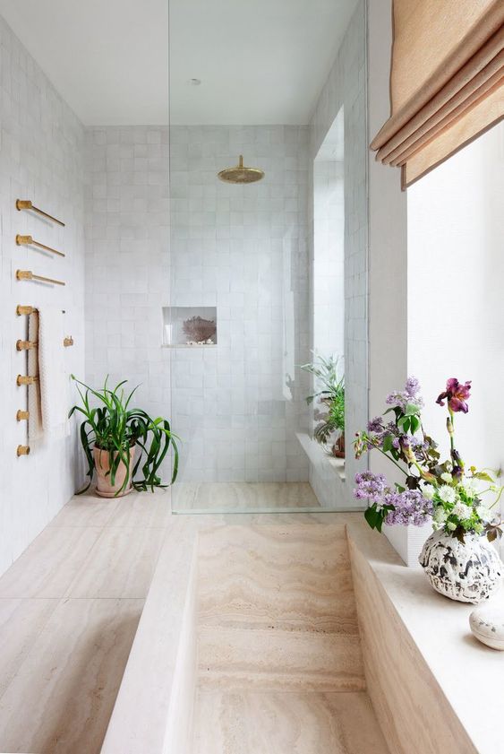 a neutral contemporary bathroom with blooms and greenery in pots and touches of gold for a chic and lively look