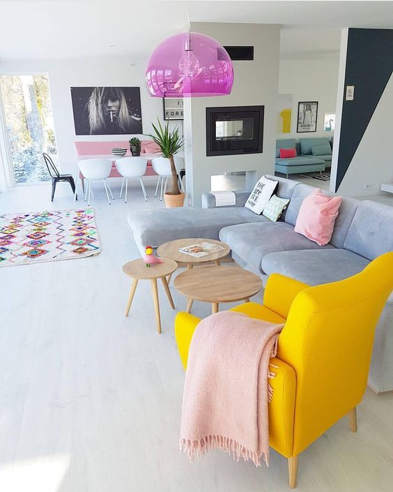 a spring living room zone with a bold yellow chair, pink linens, a hot pink sheer pendant lamp