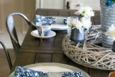 a vintage-inspired sprign table setting with navy printed napkins, a white and blue floral centerpiece and printed porcelain
