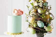 an Easter flower arrangement designed as a tree – with vines, greenery, blooms and pastel eggs